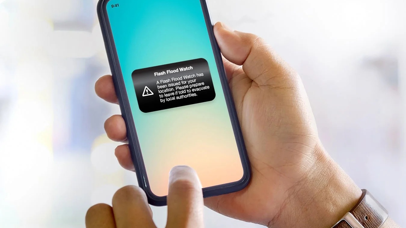 Mobile phone displaying emergency flood alert notification - automated warning system